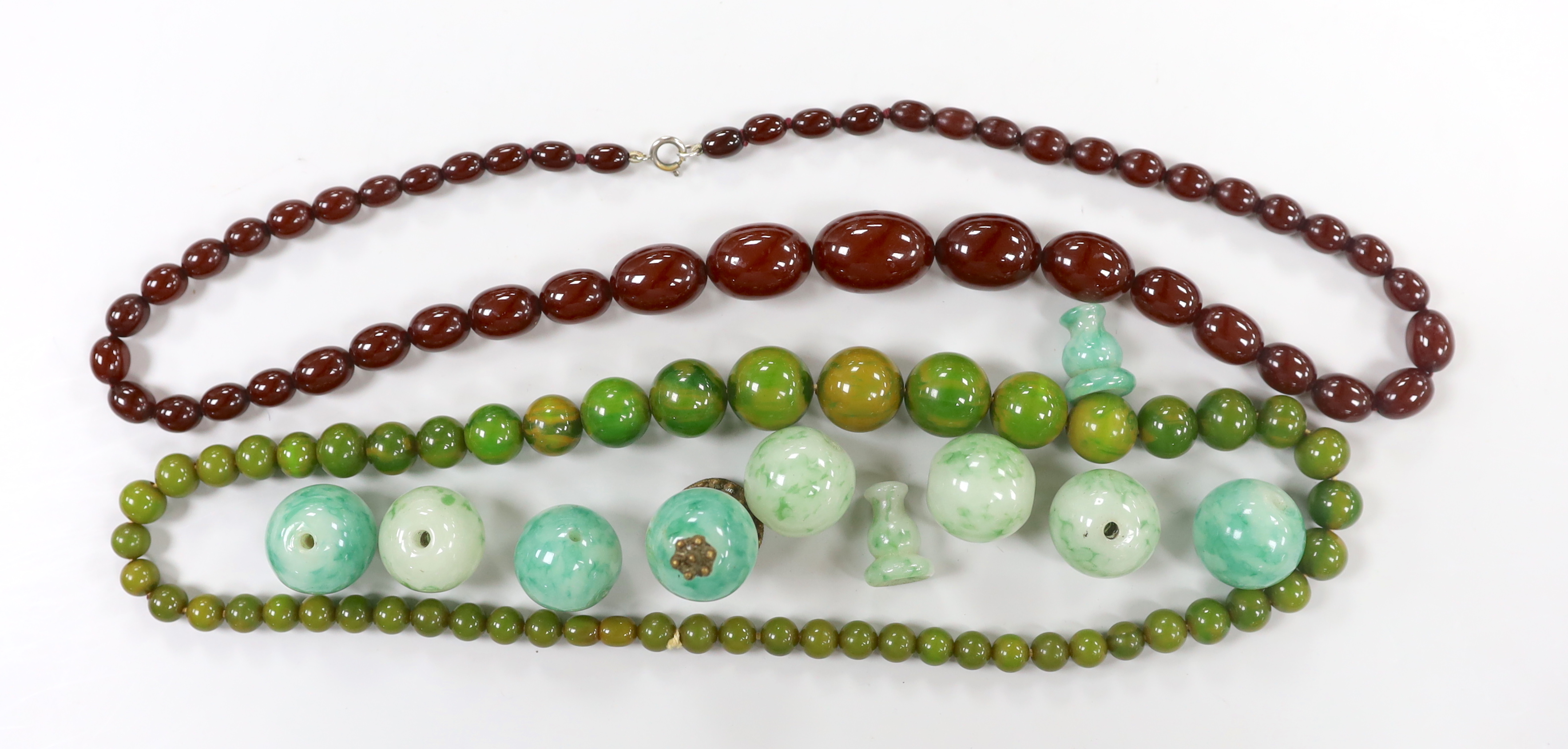 A single strand graduated simulated cherry amber necklace, one other necklace and some loose beads